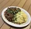 Ropa vieja and rice on a plate with cilantro on top. 